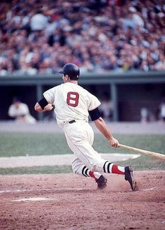 a baseball player is running to first base with the bat in his hand as he runs toward home plate