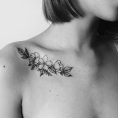 a woman's chest with flowers and leaves tattooed on her left side breast piece