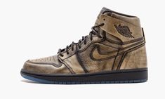 Like Michael Jordan’s storied NBA career, the Air Jordan 1 Retro High “Wings” is layered – the word “layer” here, however, should be taken in a more literal sense. Created in a limited run of 19,400 pairs, the shoe is a visual representation of Jordan’s inner-confidence, as depicted by a gold undertone layer that appears atop of a black leather upper. The details on the shoe are stunning: ‘Wings’ detailing can be seen under the flap on the ankle paneling, the heel sports MJ’s iconic outstretched Luxury Brown High-top Jordan Shoes, Air Jordan En Or, Jordan 1 High Stadium Goods, Gold Air Jordan 1, Jordan 1 Heirloom, Wings Shoes, Wings Black, Wing Shoes, Air Jordan 1 Retro High