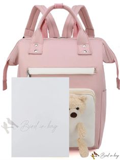 a pink backpack with a teddy bear in it and a note attached to the back