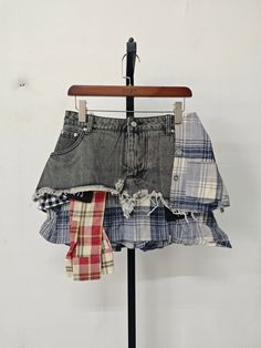 an old pair of shorts is hanging on a clothes rack with plaid napkins in front of it