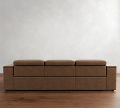 a brown couch sitting on top of a hard wood floor