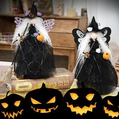 two black bags with white hair and pumpkin faces on them, one is wearing a witch costume