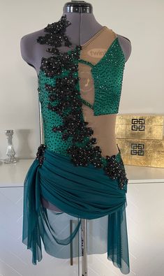 a mannequin is dressed in a green and brown dress with sequins