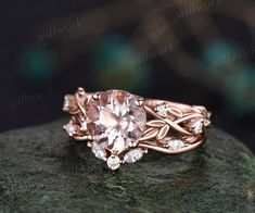 a ring with an oval shaped morganite surrounded by smaller round diamonds on a rock