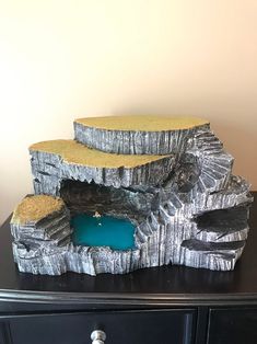 a table with a black drawer and some rocks on it that are made out of wood