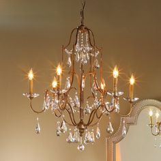 a chandelier hanging from the ceiling in a room with mirrors and a mirror