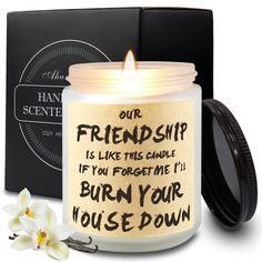 a candle that is sitting in front of a box with a flower on it and the words, our friend ship is like this candle if you forget i'll burn your house down