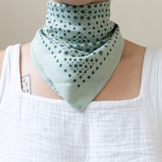 a woman wearing a green bandana with blue stars on the front and back of her neck