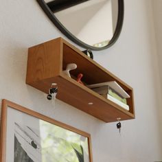 a mirror hanging on the wall next to a shelf