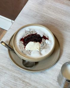 a bowl of oatmeal with fruit and yogurt on the side