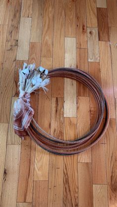 a rope and some flowers on a wooden floor