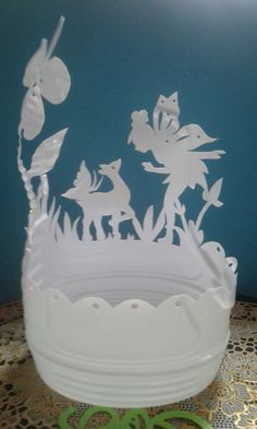 a white bowl sitting on top of a table next to a green plate with cut out animals