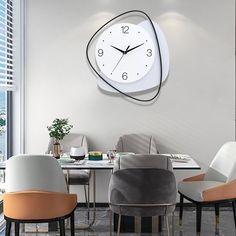 a clock mounted to the wall above a dining room table with chairs and a vase