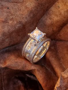 a wedding ring sitting on top of a leaf