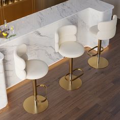 three white bar stools in front of a marble counter