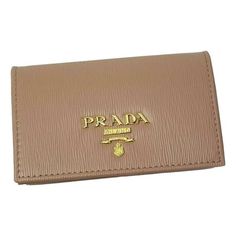 This Prada card case wallet features beautiful neutral leather that makes it the perfect accessory for anybody. The Prada Paris logo featured on the front is eye-catching. Its large interior and two slip pockets mean organizing is a breeze. You'll never want to leave home without this sophisticated wallet. Includes authenticity cards and Prada box. Model: 1MC122 Measurements: 4.5" x 1" x 2.5" (LWH) Cipria Beige vitello grain leather Card holder/wallet Gold Prada Paris logo Made in Italy Includes Leather Card Holder Wallet, Paris Logo, Card Case Wallet, Leather Card Case, Leather Card Holder, Card Holder Wallet, Card Holder Leather, Handbag Accessories, Cloth Bags