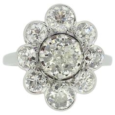 Here we have a fabulous cluster ring crafted in France and featuring a scintillating ensemble of diamonds. At the centre of this vintage piece we find a single round faceted old European cut diamond which sits slightly risen in an 8 clawed setting. This principal stone is then surrounded by a circulating array of bright white, matching old cut diamonds around the outer edge. All diamonds have been expertly individually set whilst collectively sitting atop a plain polished band. Condition: Used ( Vintage Diamond White Platinum Halo Ring, Vintage Platinum Cluster Diamond Ring, Vintage Platinum Halo Ring In Diamond White, Heirloom Style Brilliant Cut Cluster Ring, Heirloom Brilliant Cut Cluster Ring, Heirloom Style Cluster Ring With Brilliant Cut, Antique Brilliant Cut Diamond White Cluster Ring, Antique Cluster Diamond Cut Diamond Ring, Vintage Diamond White Cluster Ring With Diamond Cut