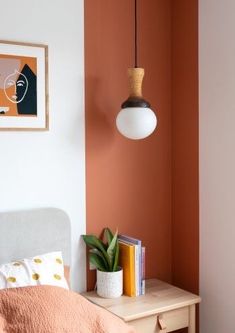 a bedroom with an orange wall and white bed