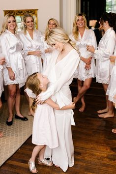 the bride and her flower girl are getting ready to go into their wedding gowns