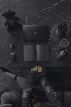 a man laying on top of a couch next to a laptop computer and other items