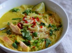 a white bowl filled with noodles and vegetables