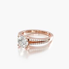 a rose gold engagement ring with an oval cut diamond in the center and side stones