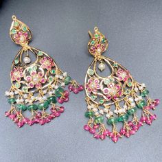 Featuring a pair of 22ct gold earrings which have been adorned with precious rubies, emeralds and pearls. Perfect for festive wear with a traditional attire. The earrings weigh 18.02 GMs including 3.55 GMs of hanging beads. These timeless gold earrings will be sure to add a sparkle to any occasion, with their high-quality 22ct gold and pristine gemstones. They offer a unique and understated elegance that will be sure to make you shine. Watch Video Here Fusion Style Yellow Gold Earrings With Tilla, Jeweled Pearl Earrings For Festive Occasions, Jeweled Pearl Earrings For Festivals, Festive Traditional Jeweled Pearl Earrings, Traditional Yellow Gold Chandelier Earrings For Festive Occasion, Green Pearl Earrings For Festive Celebrations, Green Pearl Earrings For Celebration, Festive Jeweled Pearl Earrings As A Gift, Festive Green Pearl Earrings For Celebration