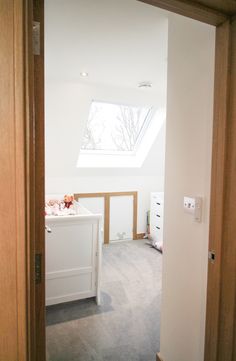 an open door leading to a bedroom with a skylight