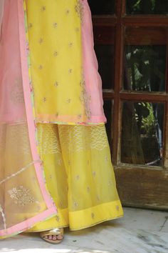 Pink, yellow panel kurta in organza base with floral gota hand embroidery. Paired with pink and yellow sharara in silk and organza base and an organza dupatta.
Components: 3
Pattern: Embroidered
Type Of Work: Floral
Neckline: Notched
Sleeve Type: Three quarter
Fabric: Organza, Silk, Lining: Shantoon
Color: Pink, Yellow
Other Details: 
Side slits
Sheer dupatta
Border detailing
Occasion: Wedding - Aza Fashions Yellow Tissue Silk Kurta With Zari Work, Yellow Saree Set With Zari Work, Yellow Chanderi Kurta With Sheer Dupatta, Yellow Anarkali Kurta In Tissue Silk, Traditional Yellow Georgette Palazzo Set, Yellow Palazzo Set With Zari Work, Yellow Anarkali Set With Straight Kurta And Sheer Dupatta, Festive Yellow Palazzo Set With Straight Kurta, Yellow Tissue Silk Kurta For Diwali