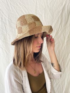 This bucket hat is casually chic and made for the beach. Beautifully crocheted in a neutral, checkerboard pattern. ﻿One size fits all. Includes adjustable strap. Brim can be folded up as pictured. Adjustable Plaid Hats For Beach, Plaid Curved Brim Hat For Beach, Plaid Curved Brim Hat For The Beach, Plaid Bucket Hat For The Beach, Plaid Summer Beach Hat, Plaid Hats For Summer Beach, Summer Gingham Hat With Curved Brim, Summer Plaid Brimmed Hat, Summer Plaid Bucket Hat