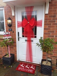 a welcome mat with a red bow on the front door