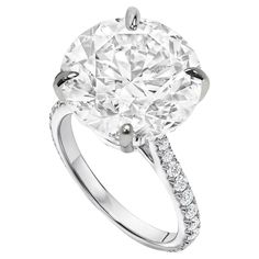 an oval cut diamond ring with diamonds on the band and shoulders, set in 18k white gold