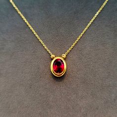 18K Solid Gold Diamond-cut Cubic Zirconia Charm Necklace, 18K Solid Gold Cable Chain, Oval Shape Red Stone Charm Necklace, Anniversary, Christmas Gift for Her/Mom! --- Created in GURANTEED HIGH QUALITY 18-Karat SOLID GOLD --- * More details: Total Gram weight: 3.80 gr Chain Length: 18.5 inches Chain Thickness: 1 millimeter Chain Style: Cable Closer: Spiring ring Pendant Height: 11 mm (millimeter) Pendant Width: 9 mm Stone: Red Cubic Zirconia This magnificent charm necklace secures with a spiring ring clasp. This perfect jewelry makes you become the center of attention! * 18K Solid Gold: 18k solid gold pieces are made to last forever. Solid 18K gold jewelry is the most expensive and high quality option as it doesn't rub off or flake, and doesn't tarnish. Solid gold actually increases in val Gold Oval Ruby Necklace, Oval Ruby Gold Necklace, Red Oval Necklace For Formal Occasions, Red Oval Necklaces For Formal Occasions, Classic Red Oval Pendant Necklace, Red Oval Pendant Necklace With Birthstone, Oval Red Necklace For Anniversary, Red Oval Necklace For Anniversary, 18k Gold Jewelry