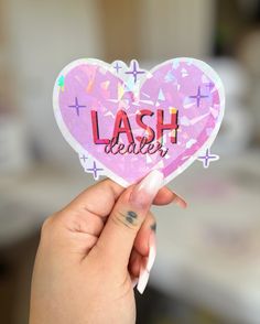 a person holding up a sticker with the word lashes written on it