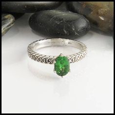 This Josephine's Knot band set with a 5x7mm Tsavorite Garnet. The strands intertwine continuously around the band to symbolize eternal love. This oval tsavorite lover's knot ring pictured in 14K White gold, but is also available in 14K Yellow, Rose or White Gold in sizes 4 - 12. Please message us for extended sizing prices. If you love this ring, but tsavorite just isn't for you send us a message! We'd be happy to find and price the perfect gemstone for you. Whether you want an emerald cut moiss Oval Tsavorite Ring In White Gold, Oval Tsavorite White Gold Ring, Oval Peridot Solitaire Jewelry, Oval Green Tsavorite Jewelry, Oval Tsavorite Jewelry For Anniversary, Tsavorite Solitaire Ring, Tsavorite Engagement Ring, Knot Engagement Ring, Celtic Love Knot