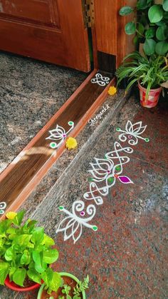 a potted plant sitting on top of a sidewalk next to a wooden door frame