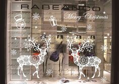 a store window decorated with christmas decorations and reindeer silhouettes