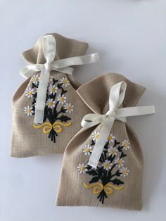 two small bags with embroidered flowers on them