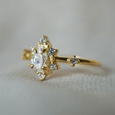 a close up view of a diamond ring on a white cloth with the background visible