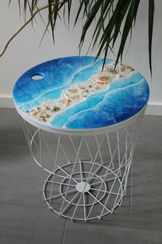 a table that has some kind of design on it, and is sitting in front of a palm tree