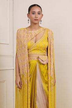 Yellow cape with sequin, bead, cutdana, pearl embroidery in geometric pattern. Paired with backless angrakha padded choli, dhoti skirt, belt and bag. - Aza Fashions Navratri Dupatta With Cutdana And Cape Sleeves, Diwali Lehenga With Cape Sleeves And Cutdana, Diwali Lehenga With Cutdana And Cape Sleeves, Traditional Navratri Set With Cape Sleeves, Traditional Sharara With Gota Work And Cape Sleeves, Bollywood Style Choli With Cape Sleeves And Cutdana, Traditional Dupatta With Cape Sleeves For Navratri, Diwali Choli With Cutdana And Cape Sleeves, Traditional Navratri Dupatta With Cape Sleeves