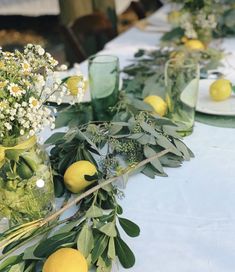 the table is set with lemons and greenery