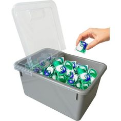 a plastic container filled with lots of green and white balls in it's lid