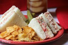 a red plate topped with sandwiches and chips