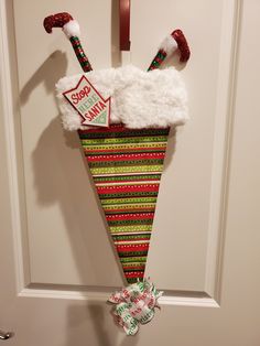 a christmas stocking hanging on the front door with candy canes attached to it