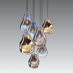 a bunch of glass vases that are hanging in the air with some lights on them