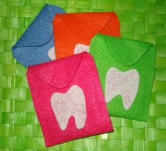 four different colored tooth shaped towels sitting on top of a bamboo mat