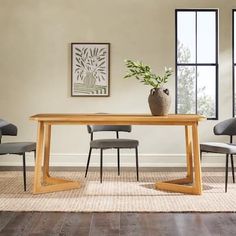 a dining room table with chairs and a vase on the table in front of it