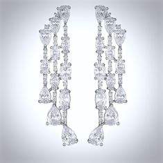 A delightfully unique pair of bridal earrings with an incredible sparkle! Adorned with flawlessly faceted cubic zirconia that capture the light in a dazzling array of sparkles, the earrings are rhodium plated for a bright finish which enhances the intricate detailing and conveys a modern take on old elegance. Overall length of the earring is 52mm (approx. 2"). Hypoallergenic - lead, nickel and cadmium free. This exquisite design will add a touch of sophistication to any wedding gown or formal en Cubic Zirconia Bridal Earrings, Silver Wedding Jewelry, Bridal Earrings, Exquisite Design, Wedding Gown, The Light, Rhodium Plated, Diamond Bracelet, Wedding Jewelry